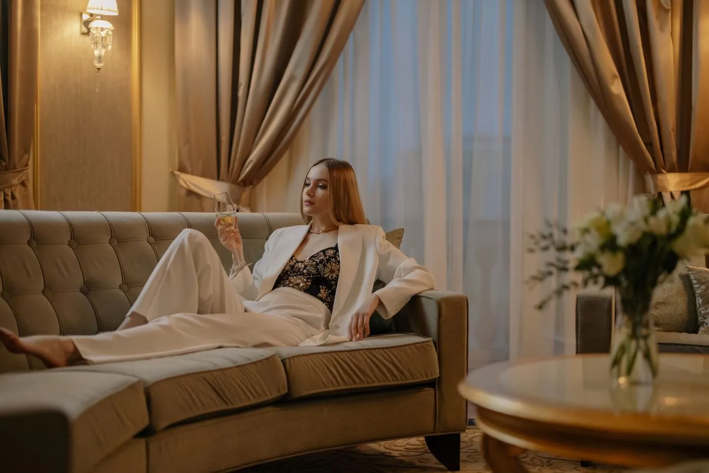 Woman relaxing on a sofa in a luxury hotel suite